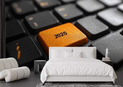 Keyboard with a key that says 2025 on it. The key is orange and is in the middle of the keyboard. Orange start 2025 button on modern keyboard closeup Wall mural