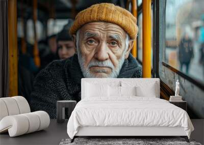 Man sits in a yellow bus with a crowd of people around him. The man is looking out the window, and the bus is crowded. old man sititng in a crowded bus Wall mural