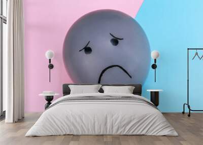 Balloon with a sad emotion on a blue-pink background.. Wall mural