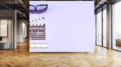 Movie clapperboard, glasses, popcorn and film strip on lilac. Wall mural