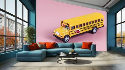 School bus isolated on pink.
An isolated toy school bus stands on the right on a pink background diagonally, side view close-up. Concept back to school. Wall mural