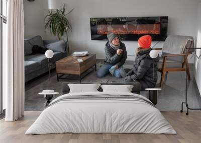 Family at home in warm winter clothes play a fun game Wall mural