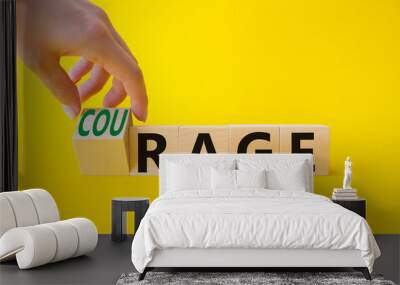 Courage and rage symbol. Businessman hand turnes wooden cubes and changes word Rage to Courage. Beautiful yellow background. Business concept. Copy space. Wall mural