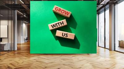 Grow with us symbol. Wooden blocks with words Grow with us. Beautiful green background. Business and Grow with us concept. Copy space. Wall mural