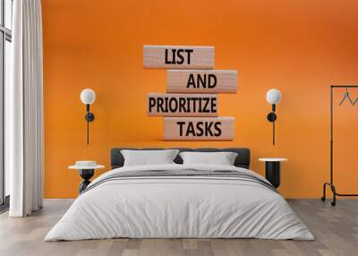 List and prioritize tasks symbol. Concept words List and prioritize tasks on wooden blocks. Beautiful orange background. Business and List and prioritize tasks concept. Copy space. Wall mural