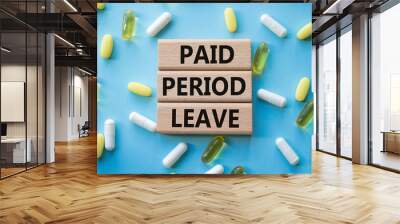 Paid Period Leave symbol. Concept words Paid Period Leave on wooden blocks. Beautiful blue background with pills. Healthcare and Paid Period Leave concept. Copy space. Wall mural