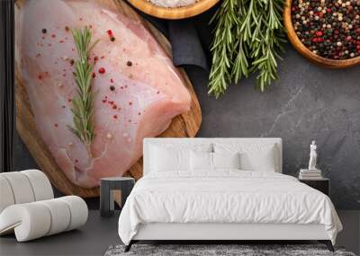 Raw turkey fillets on black cutting board with spices and herbs. Cooking ingredients. Natural healthy food concept. Top view with space for text Wall mural