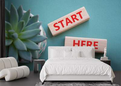 Start here symbol. Wooden blocks with words Start here Beautiful grey green background with succulent plant. Business and Start here concept. Copy space. Wall mural