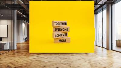 Together Everyone Achieves More symbol. Concept words Together Everyone Achieves More on wooden blocks. Beautiful yellow background. Business concept. Copy space. Wall mural