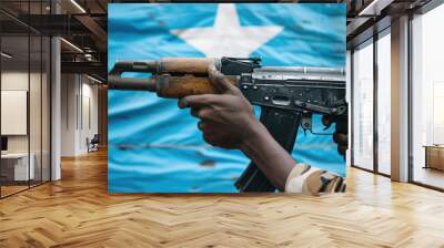 Automatic rifle in hands of soldier against Somalia flag, white star and blue background, machine gun close-up. Theme of Somali freedom, pirates, war, military, weapon Wall mural