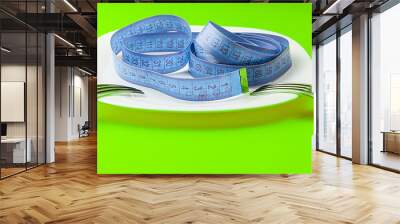 Centimeter on a white plate and two forks against a colored background, top view. Healthy food, calorie content. Diet, fitness concept. Selective focus. Wall mural