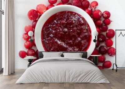 Crenberry jam in white bowl  and frozen fresh moos-berries on white plate Wall mural