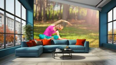 girl doing yoga outdoors in the forest. It supports a healthy lifestyle Wall mural