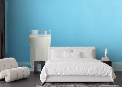 Glass of milk on pastel blue background Wall mural