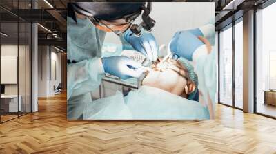 Dentists will perform an operation, implant placement. Real operation. Tooth extraction, implants. Professional uniform and equipment of a dentist. Healthcare Equipping a doctor’s workplace. Dentistry Wall mural