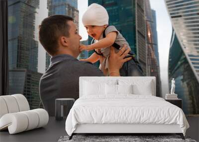 Father and one year old son against the sky and skyscrapers. Travel with children, the development of emotional intelligence. Early development. Wall mural