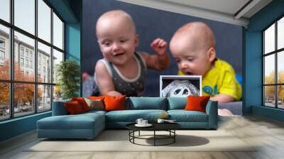 Photo ultrasound twins. In the background are twins, a boy and a girl of 7 months. Maternity. Wall mural