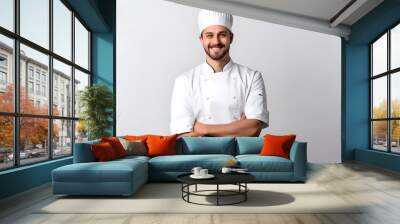 photo of the chef of a smiling European chef in a white cap and white tunic with bent arms isolated on a white background Wall mural