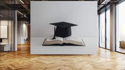 A mortarboard and graduation scroll on open books on whire background. education learning concept Wall mural