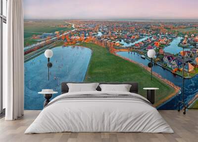 Aerial view on the traditional village Koudum with the ice rink in Friesland the Netherlands at sunset in winter Wall mural