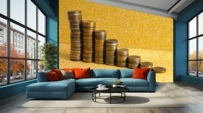 Stacks of coins with growth between stacking limits on gold background.  Wall mural