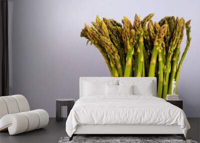 on the right is a bunch of green raw young asparagus on a lilac background. vitamin-rich food. vegetables Wall mural