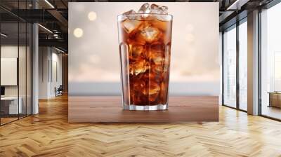 A cocktail of liquid amber in a highball glass with ice cubes, on a wooden table Wall mural