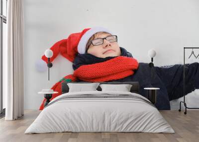 a young guy in a santa hat lies in the snow, fun concept, on the eve of christmas Wall mural