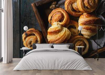 Variety of homemade puff pastry buns cinnamon rolls and croissant served with coffee cup, jam, butter as breakfast over dark plank wooden background. Flat lay, space Wall mural