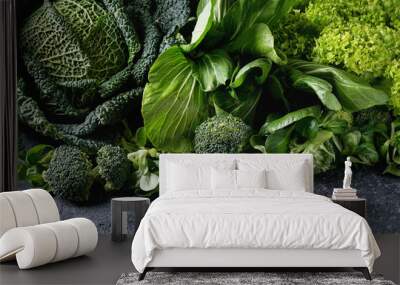 Variety of raw green vegetables salads, lettuce, bok choy, corn, broccoli, savoy cabbage as frame over black stone texture background. Space for text Wall mural