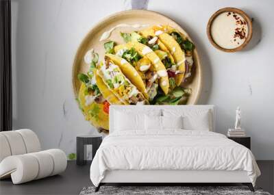 Variety of vegetarian corn tacos with vegetables, green salad, chili pepper served on ceramic plate with cream sauce over white marble background. Top view, copy space. Wall mural