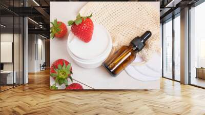 brown glass bottle of cosmetic oil, cotton reusable face sponges, cream in a jar white and red strawberries Wall mural