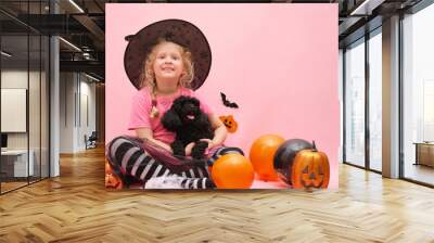 cheerful cute girl and little black mini poodle on the background of halloween scenery Wall mural