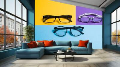 children's glasses and two pairs of adult glasses lie on a blue background, yellow and purple background for your text, copy place, optics store concept Wall mural