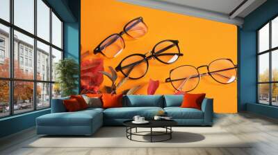 eye glasses nad red autumn leaves on orange background copy space Wall mural