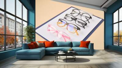 glasses on a clipboard, beige background, diagnostics of vision Wall mural