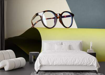 glasses on rolled paper, geometric background, green colors Wall mural