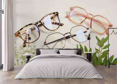 several fashionable glasses and flowers on a beige background copy space top view Wall mural