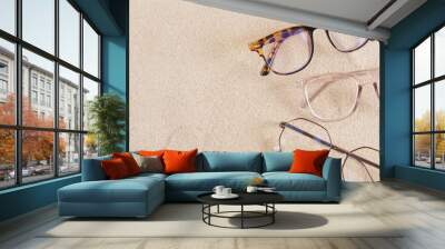 several stylish eye glasses on the sand, copy space Wall mural