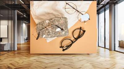 two stylish glasses on stone on background of crumpled white paper, trendy still life, accessories for vision correction Wall mural