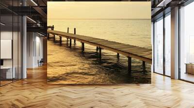 Wooden Pier Extending into Tranquil Waters at Sunset Wall mural