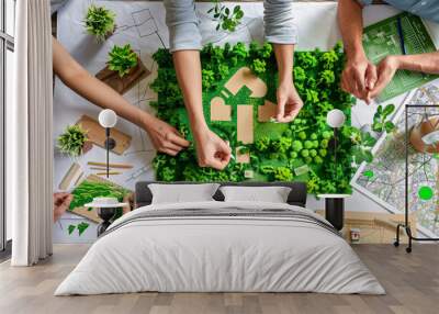 manufacturers reviewing a blueprint for a new, eco-friendly product line that meets green and conser Wall mural