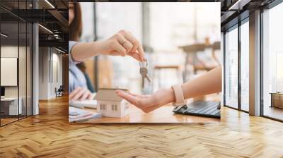 Client taking keys from female real estate agent during meeting after signing rental lease contract or sale purchase agreement. Independent woman purchasing new home, close up view. Wall mural