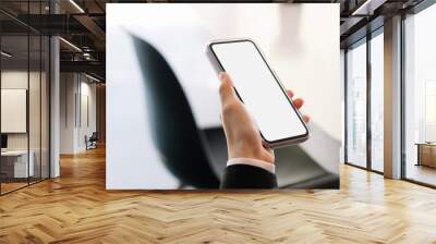 Close up woman hand holding mobile phone with blank screen for advertising Wall mural