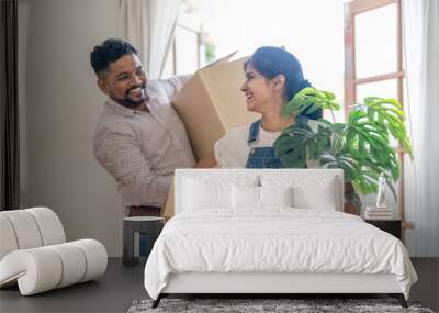 Couple indian happy carrying box on moving day in of home new Wall mural