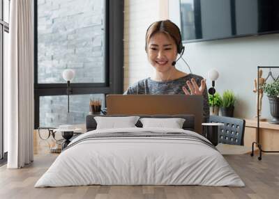 Cropped shot smiling asian woman freelancer wearing headset, communicating with client via video computer call. Millennial pleasant professional female tutor giving online language class Wall mural