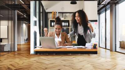 Excited african women achieving goals excited raised hands rejoicing with laptop in the office. New startup project concept. Wall mural