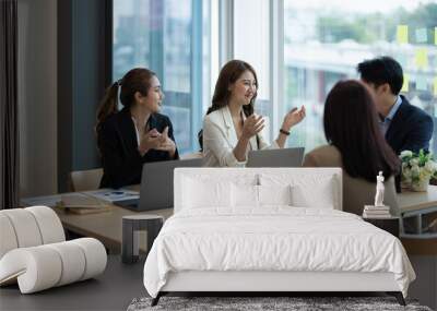 Group of young asian business people brainstorming at a meeting starting a new business in moder office Wall mural