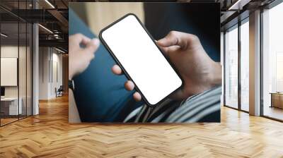 Top view man sitting and holding blank screen mock up mobile phone Wall mural