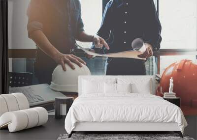 Two construction engineers working at  construction site with blueprint on table Wall mural